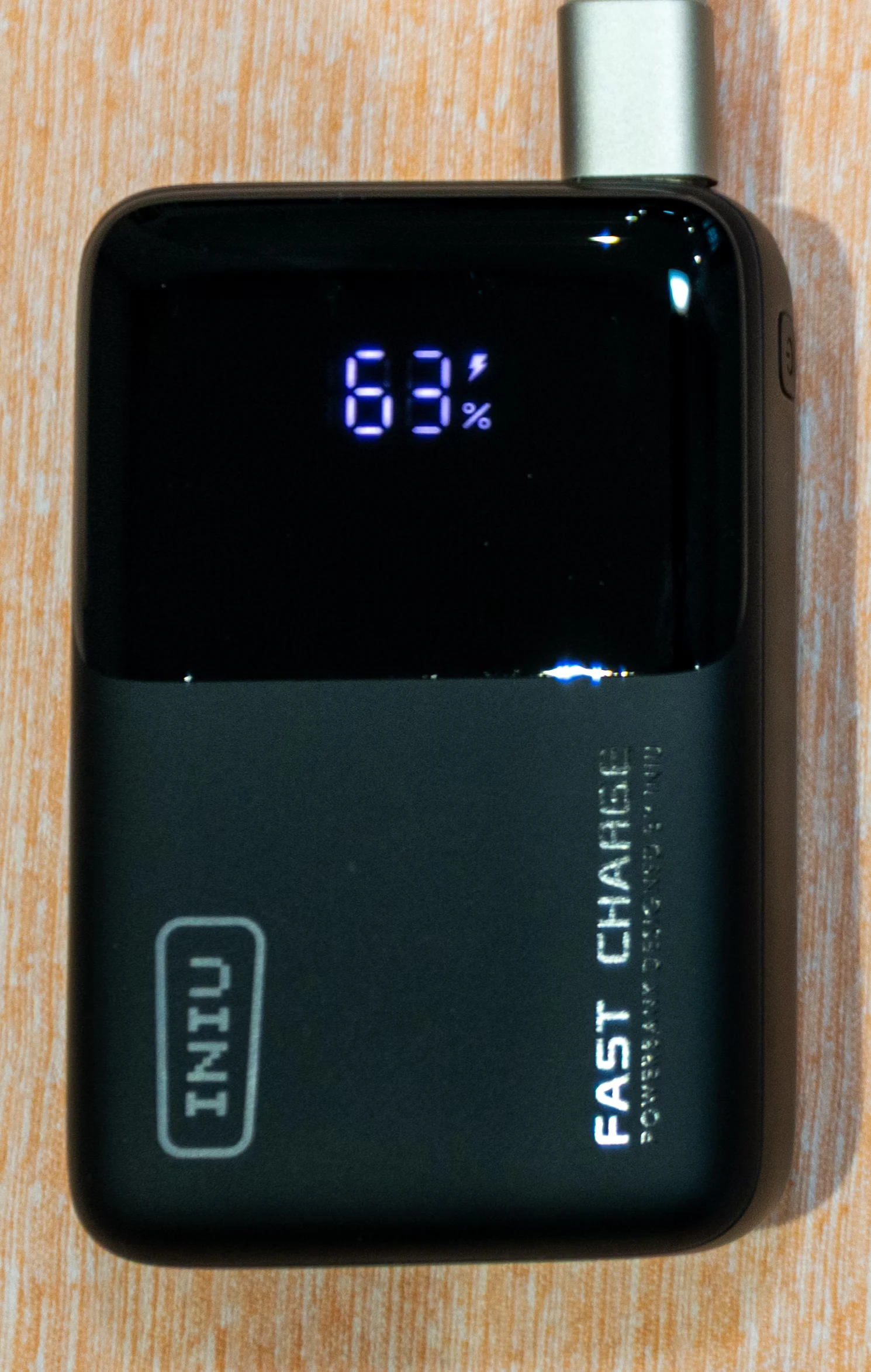 The power bank while it’s being charged, with the display showing 63% with a power icon