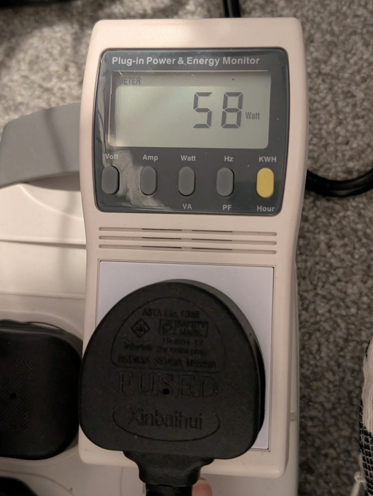 A photo of an energy monitor with a passthrough socket, reading 58W